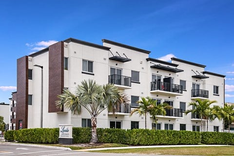 a large apartment building with palm trees in front of it