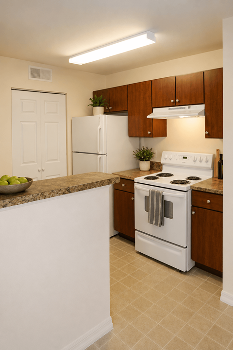 A white stove and refrigerator in a kitchen with brown cabinets.