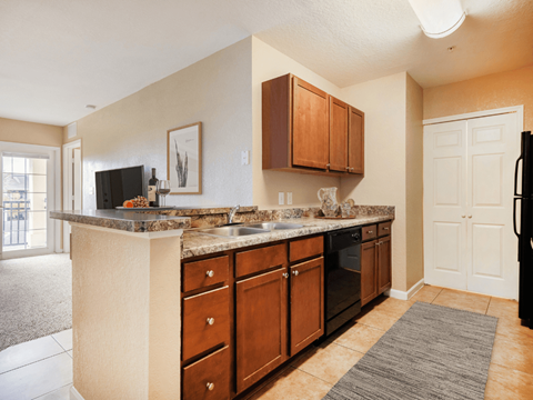 A kitchen with brown cabinets and a granite countertop.