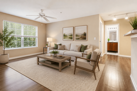 A living room with a couch, a coffee table, and a ceiling fan.