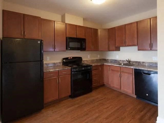 a kitchen with black appliances and wooden cabinets