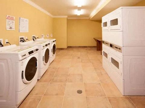 a laundry room filled with lots of white washing machines