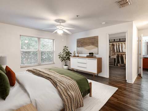 A bedroom with a bed, a dresser, and a ceiling fan.