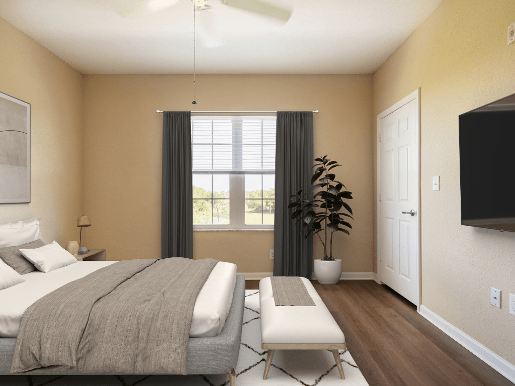 A bedroom with a bed, a bench, and a ceiling fan.