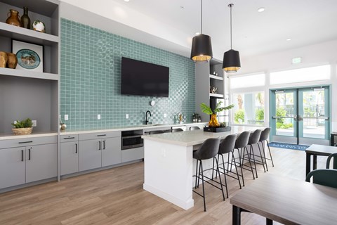 A modern kitchen with a white island and grey cabinets.
