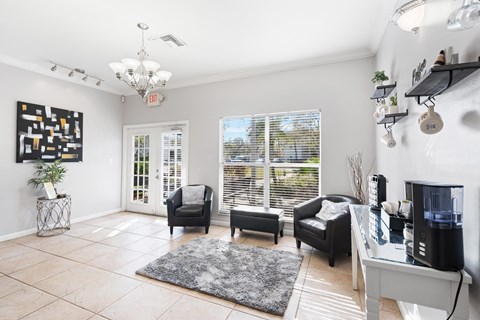 A living room with a grey rug and a black and white painting on the wall.