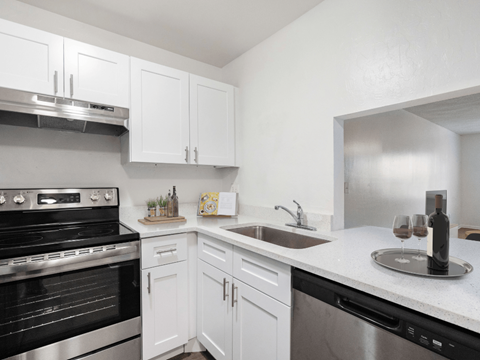 A kitchen with white cabinets and a black oven.