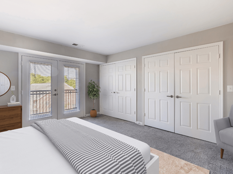 a bedroom with white doors and a bed