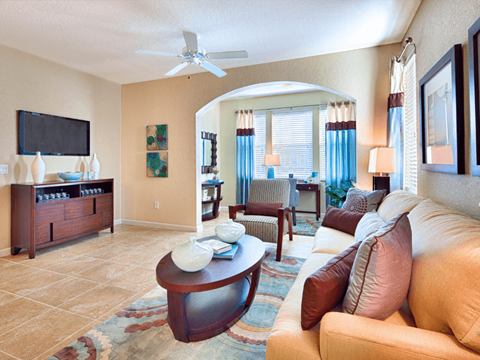 A living room with a tan couch and a wooden coffee table.