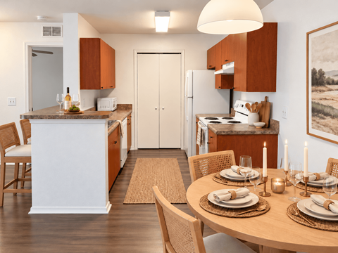 A modern kitchen with a dining table set for two.