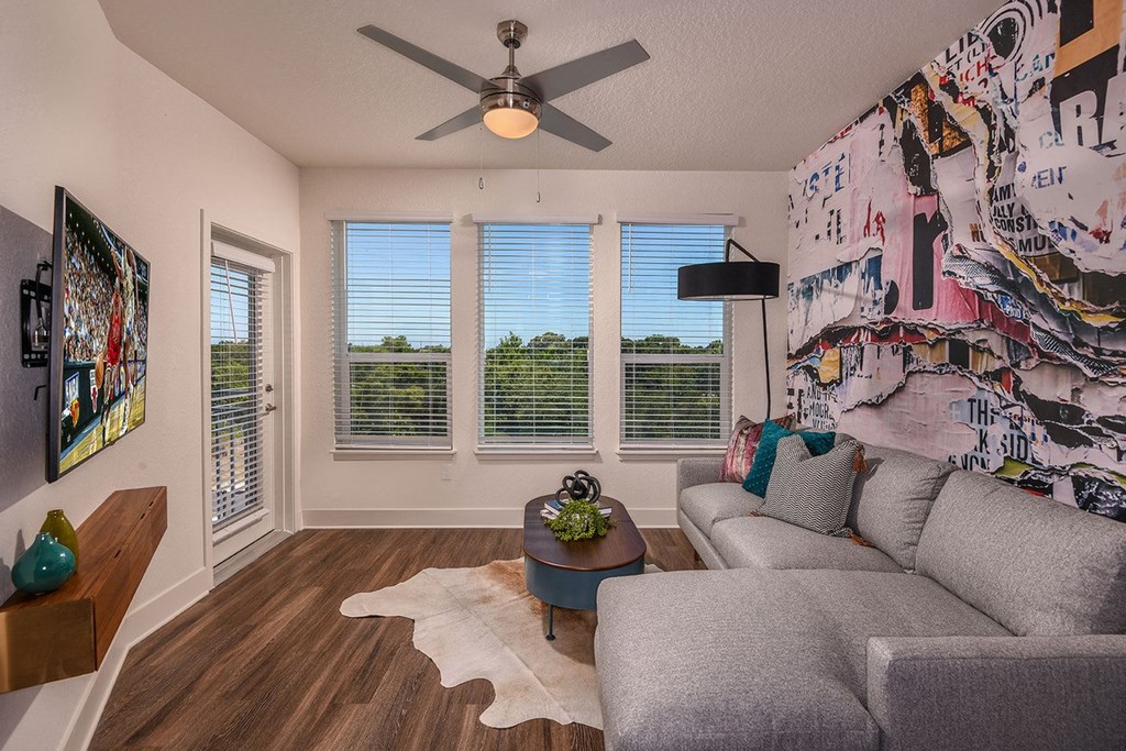 Living room with a ceiling fan and lovely views at The Exchange Luxury Apartments in St. Petersburg, FL