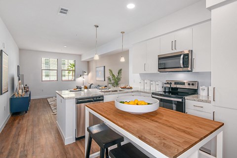 a kitchen with a bowl of fruit on a wooden table
