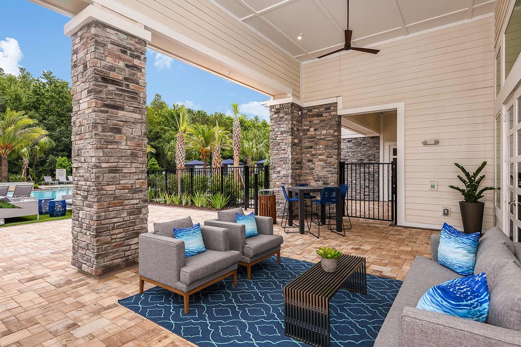 A patio with a table and chairs and a ceiling fan.