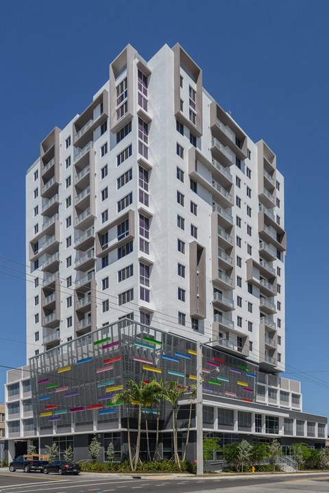 a white apartment building with a glass facade on a city street