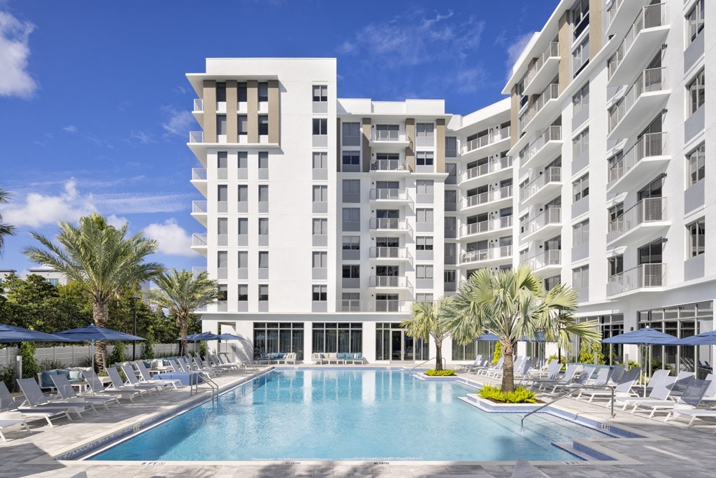 Expansive sun deck with heated pool and loungers at The Marc Apartments in Palm Beach Gardens FL