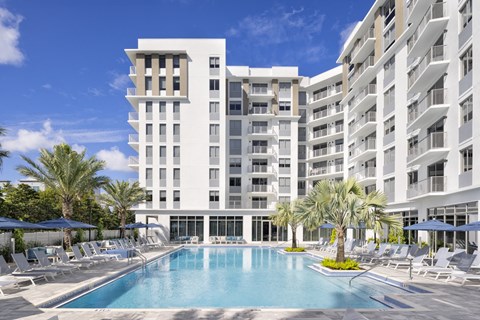 Expansive sun deck with heated pool and loungers at The Marc Apartments in Palm Beach Gardens FL