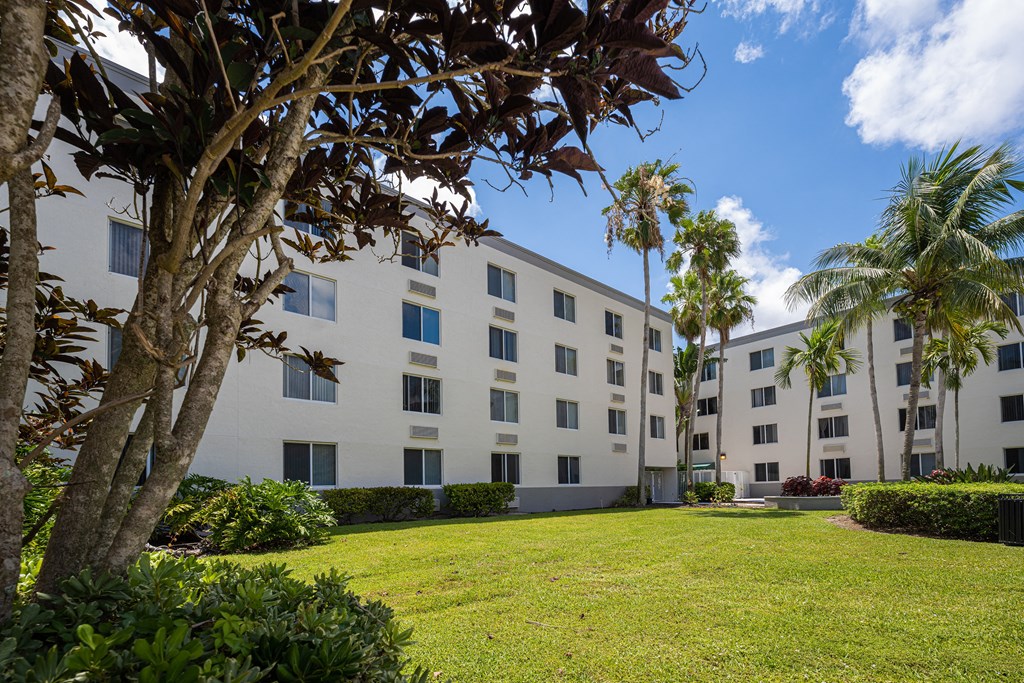 a large white building with a grassy area in front of it