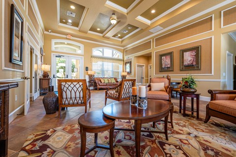 A large, well-furnished living room with a patterned rug and wooden furniture.