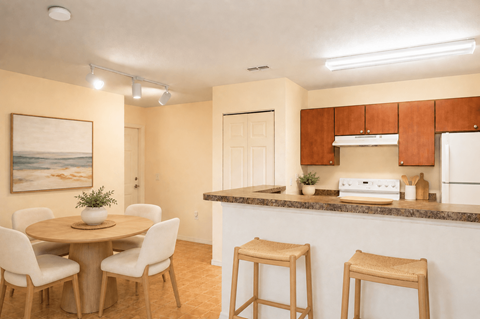 A kitchen with a table and chairs and a painting on the wall.