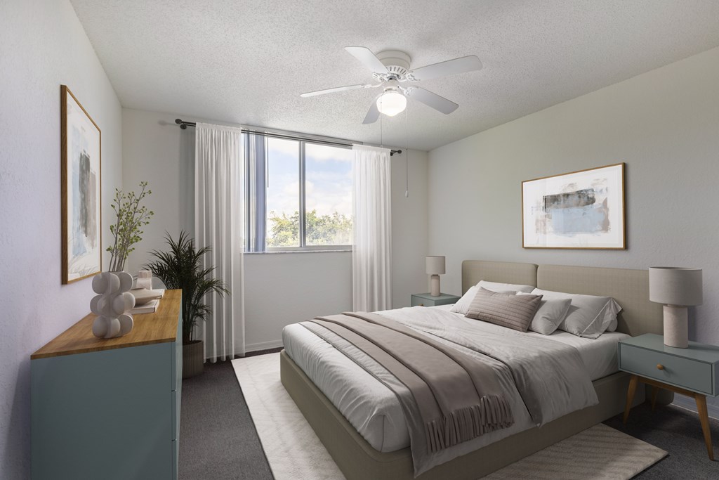 A bedroom with a large bed and a ceiling fan.