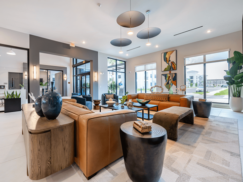 A modern living room with a large sectional sofa, a wooden side table, and a large abstract painting on the wall.