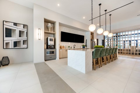 A modern kitchen with a white counter and green chairs.