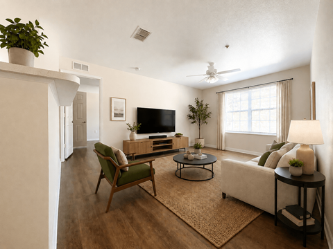 A living room with a green chair, a black television, and a white couch.