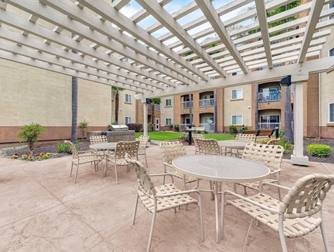 A patio with a table and chairs under a roof.