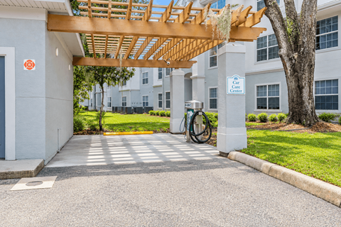 A bike rack is located under a wooden canopy outside a building.