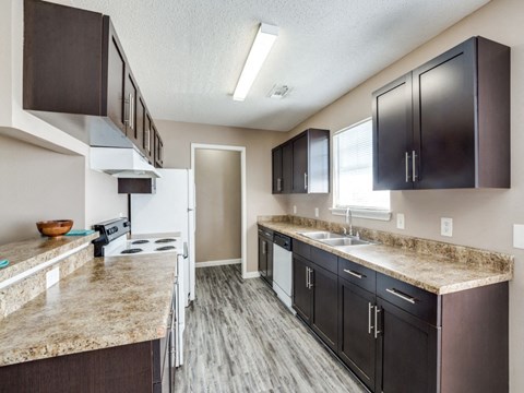 a kitchen with granite counter tops and dark cabinets