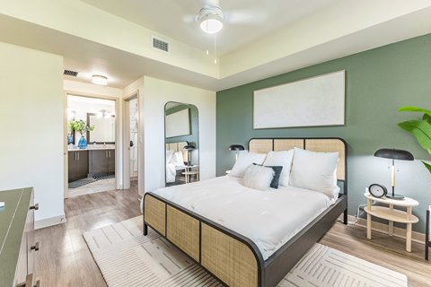 A bedroom with a large bed and a mirror on the wall.