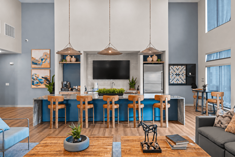 A modern kitchen and dining area with a blue accent wall and wooden floors.