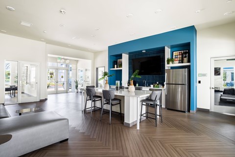 A modern kitchen with a blue accent wall and a dining table set for two.