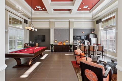 a living room with a pool table and a kitchen