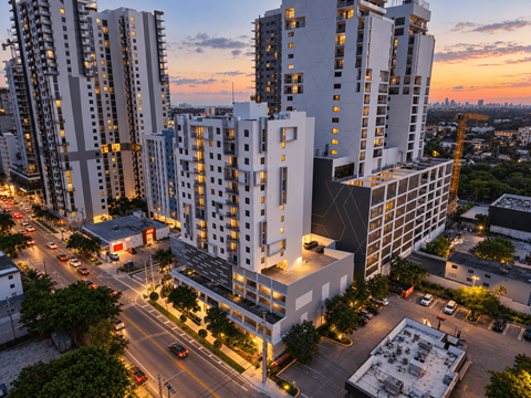 A cityscape with tall buildings and a sunset sky.