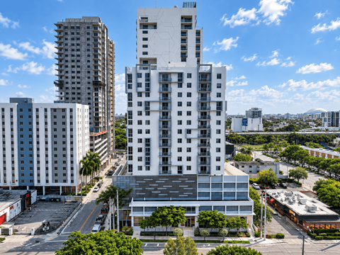 A white building stands out against the other buildings in the city.