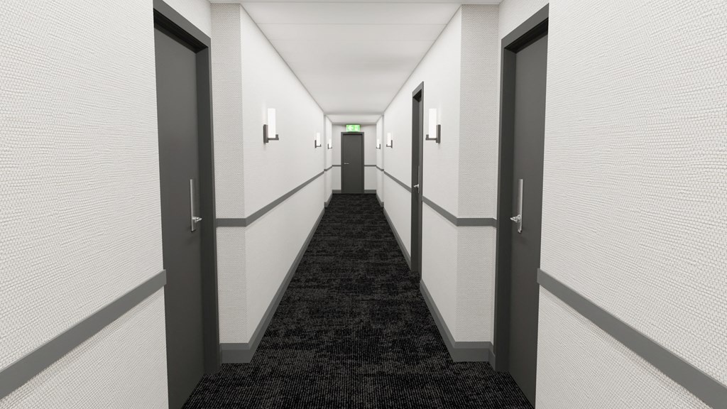 a corridor with black carpet and white walls and doors