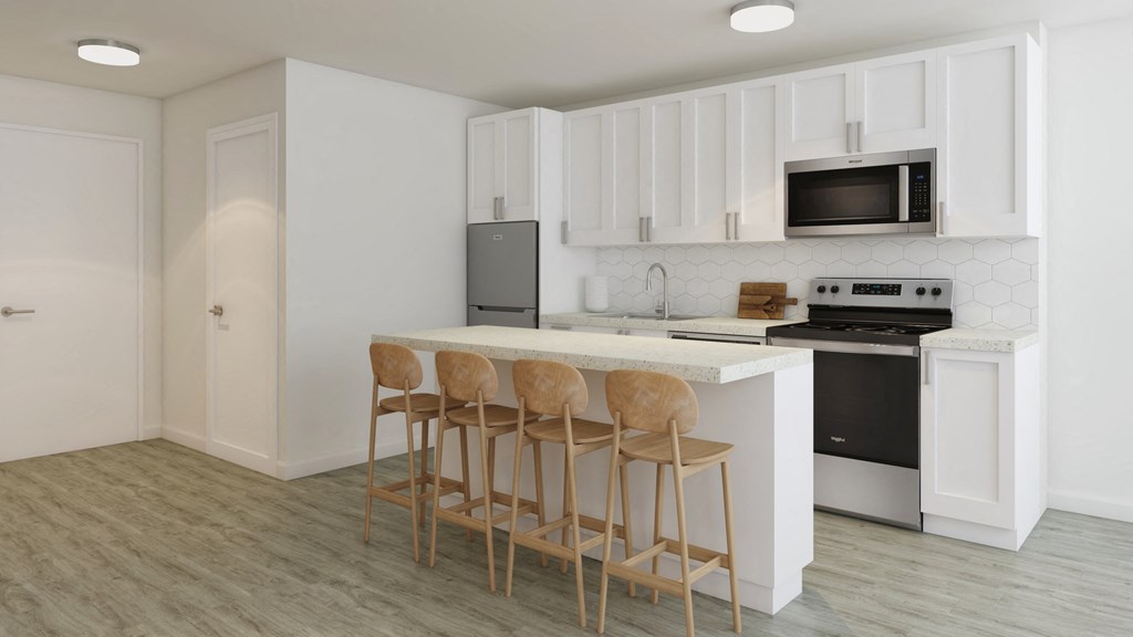 a kitchen with white cabinets and a counter with three chairs