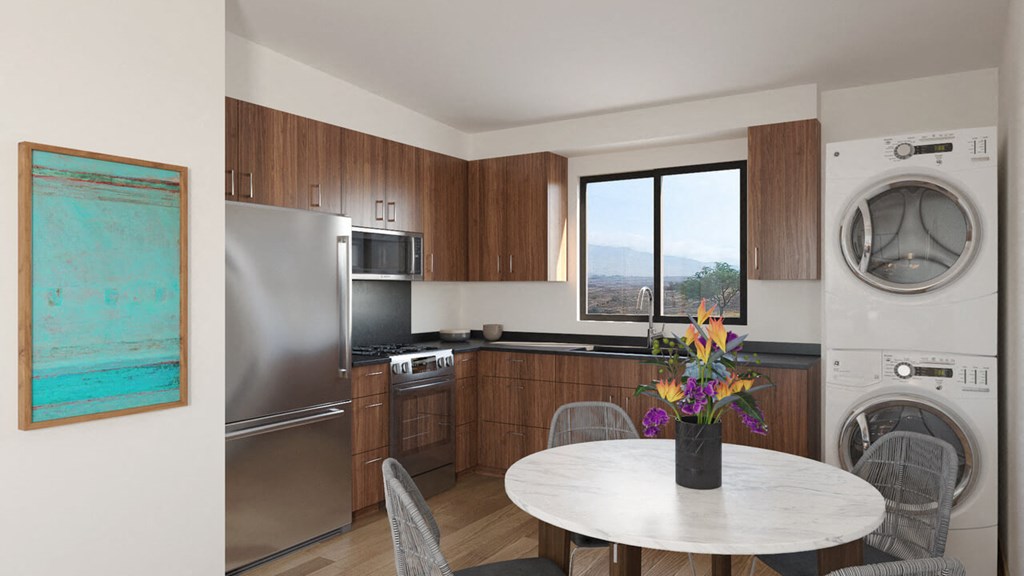 a kitchen and dining room with a washer and dryer and a white table