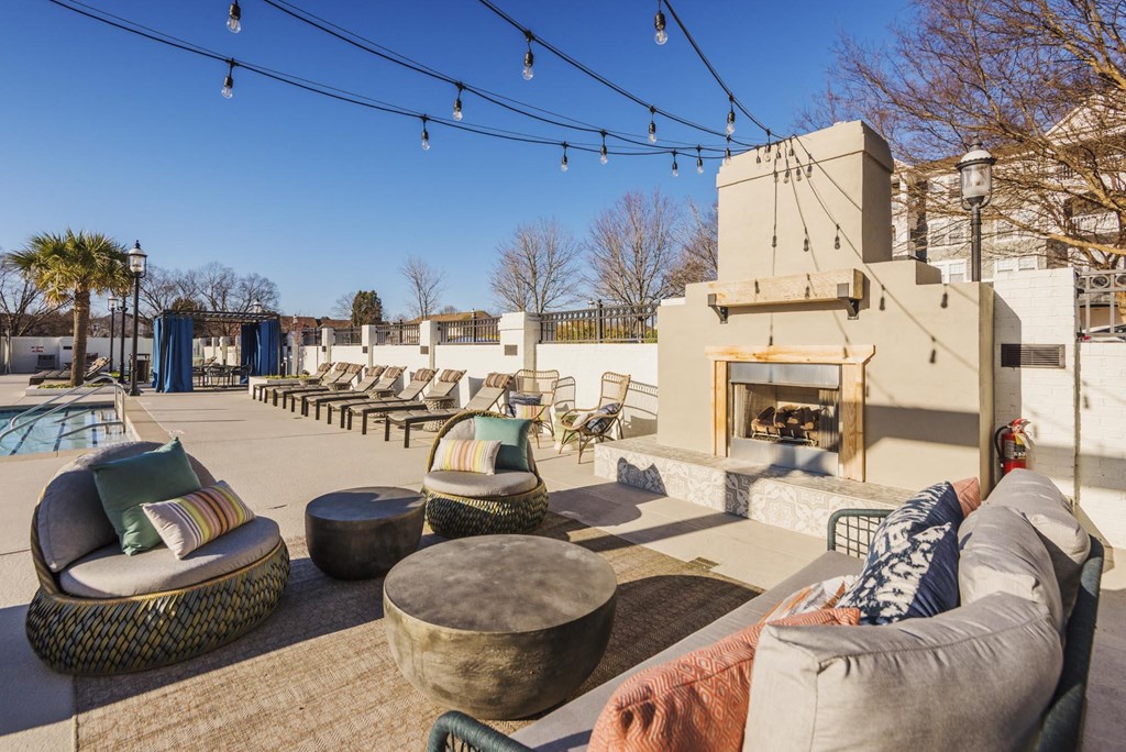 a patio with couches and chairs and a fireplace