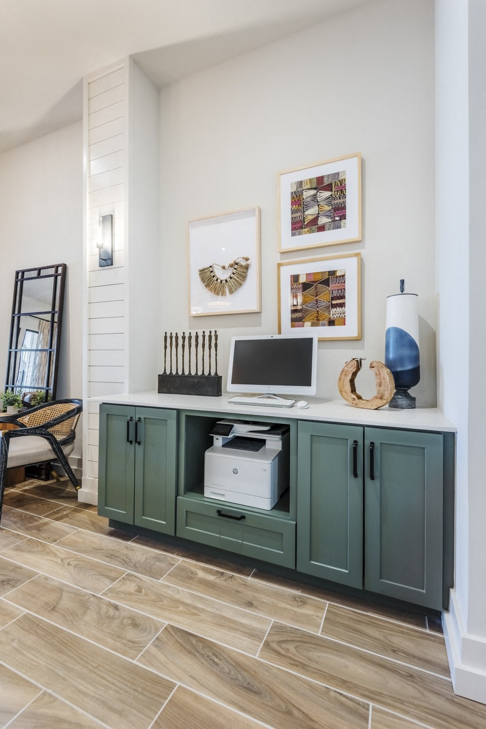 a living room with green cabinets and a computer on a desk