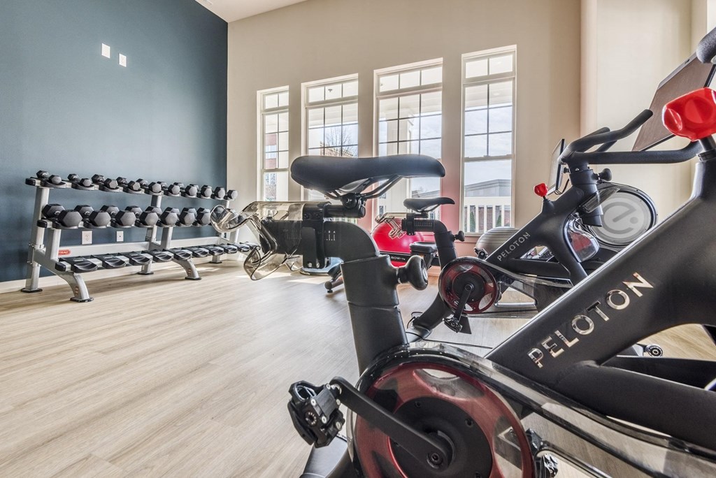 a spin class room with bikes and dumbbells in a gym