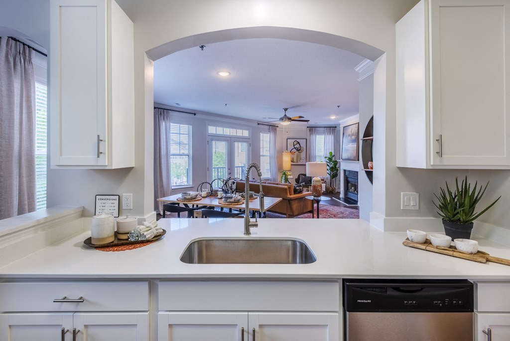 a kitchen with a view into a living room and a dining room
