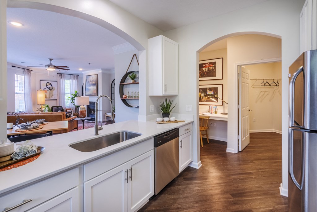 a kitchen with white cabinets and a sink and a refrigerator