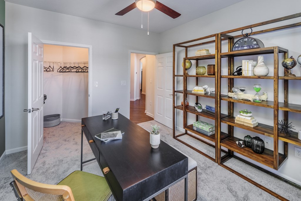 a home office with a desk and a bookshelf