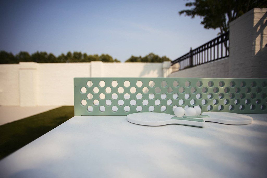 a white table with a white spoon and a white chair