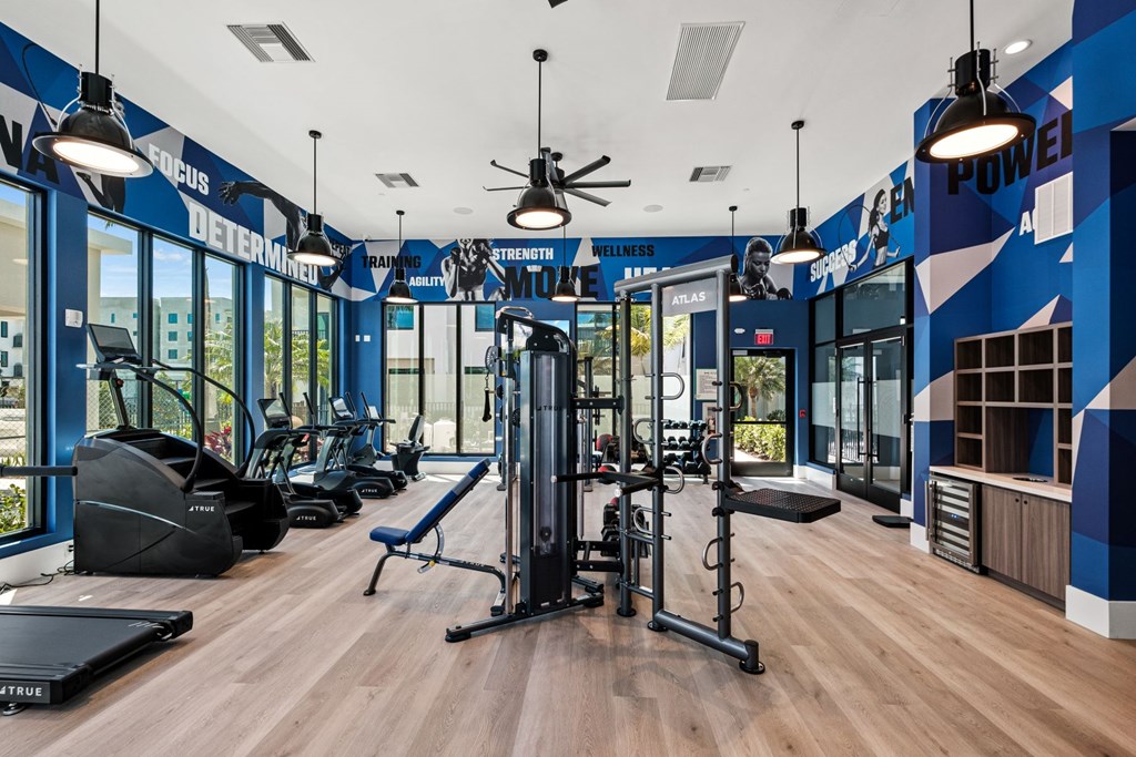 A gym with a variety of equipment including a treadmill, a bench, and a weight machine.