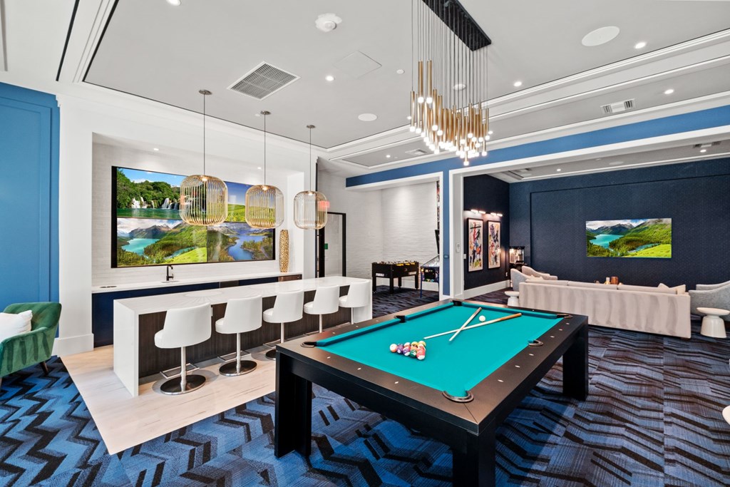 A lounge area with a pool table and a television.