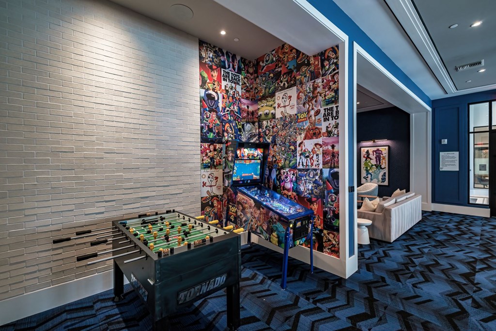 A lounge area with an array of games such as pinball and foosball
