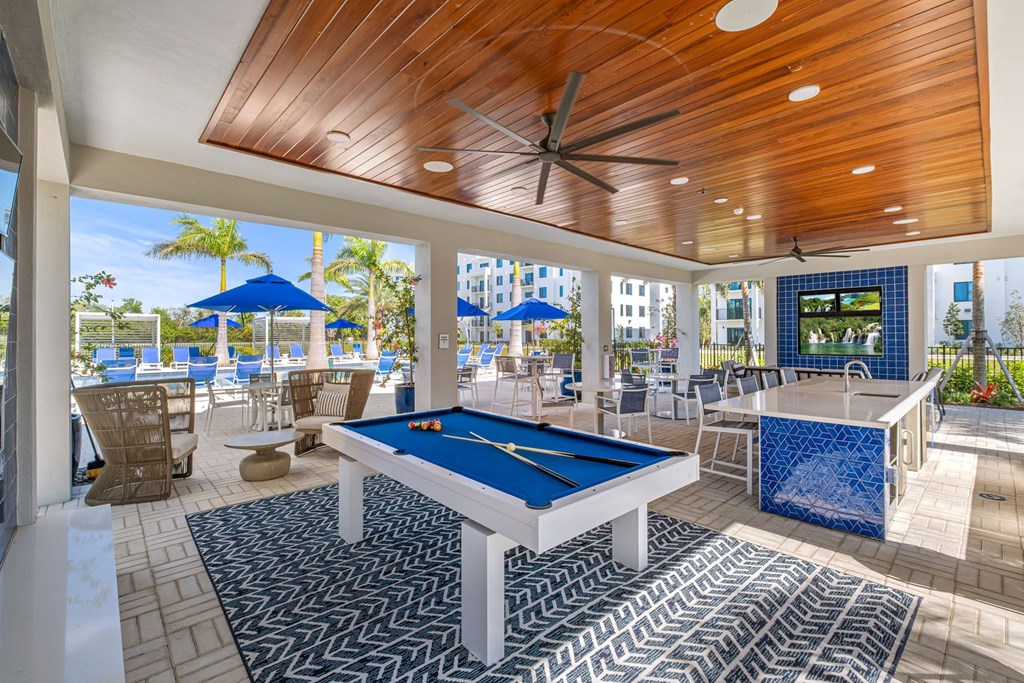 A pool table is in the middle of a room with a blue and white tiled floor.